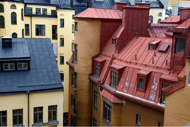 Vy över hustak och fönster över flera gamla lägenhetshus i centrala Stockholm